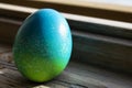 Vivid colored egg abandoned on window