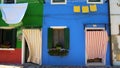 Vivid colorful houses painted in green and blue, nice flower pots on windows