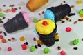 Vivid colors Ice cream in chocolade black cones with peanuts, dried fruits and caramel sweets scattered on a table