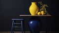 Vivid Contrasts: Lush Lemon Tree in a Sunny Yellow Pot with a Blue Stool Against a Dark Wall. Royalty Free Stock Photo