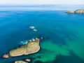 Vivid emerald-green water at Ballintoy harbour along the Causeway Coast in County Antrim. Rugged coast of Northern Ireland