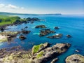 Vivid emerald-green water at Ballintoy harbour along the Causeway Coast in County Antrim. Rugged coast of Northern Ireland