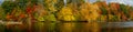 Vivid fall foliage on the Grand River river in Grand Ledge with cloudy sky Royalty Free Stock Photo