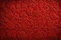 A vivid and festive red Christmas brocade fabric pattern background, featuring intricate and textured designs.