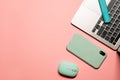 Vivid flat lay photo with a silver grey laptop, light blue computer mouse, turquoise marker, and a smartphone in a case on a pink Royalty Free Stock Photo
