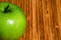 Single Green Apple with water Drops on the surface. There is Ro