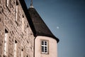 Vivid landscape shot of the roof of the Castle of Waldenburg with the moon in the background