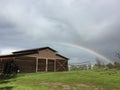 Vivid low Rainbow and barn with green grass Royalty Free Stock Photo