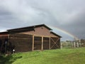 Vivid low Rainbow and barn with green grass Royalty Free Stock Photo