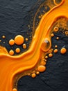 Vivid orange paint flowing and forming droplets on rough dark textured surface creating dynamic artistic pattern with glossy wet Royalty Free Stock Photo