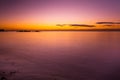 Vivid purple glowing sunset over smooth water. Royalty Free Stock Photo