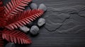 Vivid red fern leaves beautifully arranged beside smooth grey zen stones on a textured slate. Royalty Free Stock Photo