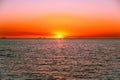 Vivid red glowing sunset over sea with small fishing boat. Royalty Free Stock Photo