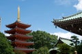 Vivid red pagoda in Fukuoka, Japan. Glowing golden spire and green trees; rooftops in foreground