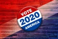 Vivid red white blue vote 2020 america button pin on wood background