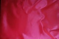 Vivid reddish pink satin fabric from above