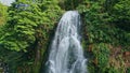 Vivid waterfall falling mountain rocks drone view. Rainforest stream rushing Royalty Free Stock Photo