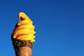 Vivid Yellow Banana with Raspberry Soft Serve Ice Cream Cone Against Sunny Blue Sky