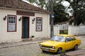 Vivid yellow Chevrolet Chevette sedan car in front of a traditional restaurant located in an old house in Lapa Royalty Free Stock Photo