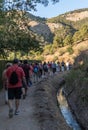 Viznar, Granada, Spain, August 18, 2022: Group of people walking next to the acequia aynadamar on the occasion of the popular Royalty Free Stock Photo