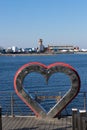 Urban landscape with a metal heart on the background of the sea.