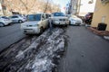 Vladivostok, Russia, 2017 - Dirty street in Vladivostok. Cars are parked in front of large muddy snow drifts on the streets of