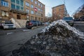 Vladivostok, Russia, 2017 - Dirty street in Vladivostok. Cars are parked in front of large muddy snow drifts on the streets of