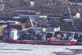 Ice-covered container ships loading at the pier at the port in the Golden Horn Bay