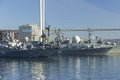 Warships of the Russian Pacific Fleet - cruiser, frigate and destroyer, at the pier in the center of Vladivostok against the backg