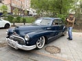 Vladivostok, Russia, May, 18, 2019. Exhibition of American retro-cars. Man photographer Buick Road Master 1950 year of manufactur