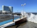 Vladivostok, Russia, October, 10, 2023. Waves on the Sports embankment against the background of Barny apart-hotel