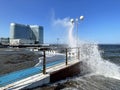 Vladivostok, Russia, October, 10, 2023. Waves on the Sports embankment against the background of the Barny apart-hotel