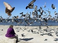 Vladivostok, Russia, October, 10, 2023. Woman feeds pigeons on the Sports Embankment in Vladivostok