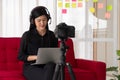 Vlog Asian woman blogger influencer sitting on the sofa in home and recording video blog for teaching and coach her Students or Royalty Free Stock Photo