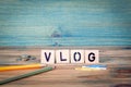 Vlog - name from wooden letters. Office desk, informative and communication background Royalty Free Stock Photo