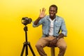 Vlog and online coaching. Portrait of cheerful friendly happy man smiling at his professional dslr camera. indoor studio shot Royalty Free Stock Photo