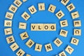 Vlog word wooden cubes on blue background Royalty Free Stock Photo