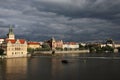 Vltava River Embankment in beams setting the sun against the background of the coming bad weather.