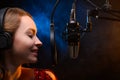 Vocalist singing in the studio. School and vocals. Against the backdrop of blue and orange smoke Royalty Free Stock Photo