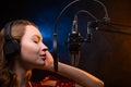 Vocalist singing in the studio. School and vocals. Against the backdrop of blue and orange smoke Royalty Free Stock Photo