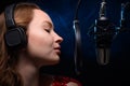 Vocalist singing in the studio. School and vocals. Against the backdrop of blue and orange smoke Royalty Free Stock Photo