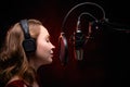 Vocalist singing in studio. School and vocals. Against the backdrop of red smoke Royalty Free Stock Photo