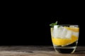 Vodka cocktail with lemon and ice on table against black background. Space for text Royalty Free Stock Photo