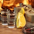 Vodka, compass, hip flask and food on the board at Fire Royalty Free Stock Photo