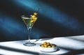 Vodka martini with olives, alcoholic cocktail drink with vodka and vermout, dark green background, bright hard light and shadow Royalty Free Stock Photo