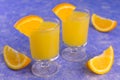 Vodka with orange juice in small glasses on a blue background. Royalty Free Stock Photo