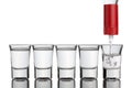 Vodka pouring into shot glasses standing in row. Royalty Free Stock Photo