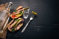 Vodka and a set of sandwiches with sprats, and caviar, onion and parsley, on a wooden background. Royalty Free Stock Photo