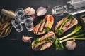 Vodka and a set of sandwiches with sprats, and caviar, onion and parsley, on a wooden background. Royalty Free Stock Photo