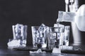 Vodka in shot glasses pouring out of the bottle on black stone background, iced strong drink in misted glass Royalty Free Stock Photo